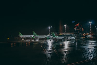 三架白绿相间的飞机在机场夜间拍摄